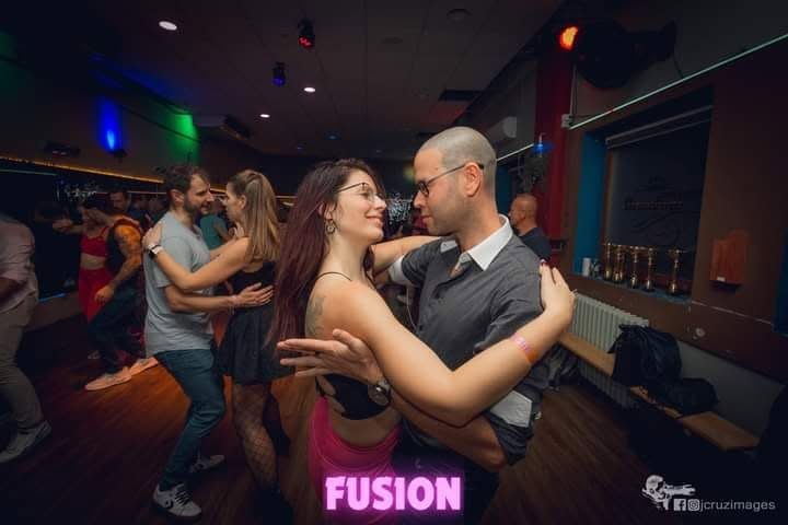 Táncoló pár neon feliratos háttérben